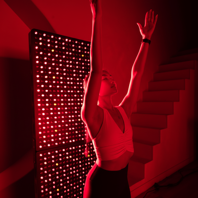 Woman with arms raised during red light therapy session